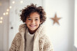 Young child with curly hair wearing a winter sweater indoors.