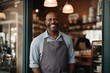 Portrait of happy man standing at doorway of his store. Cheerful mature waiter waiting for clients at coffee shop. Successful small business owner in casual wearing grey apron