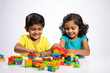 © Niks Ads - indian little siblings playing with cube toy on white background