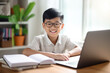 © Anna - Happy asian boy in eyeglasses using laptop computer at home