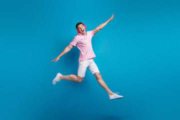 Canvas Print - Full body portrait of active crazy person jumping hands wings listen favorite song isolated on blue color background