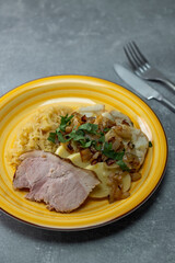 Wall Mural - pork meat with potato dumplings and pickled cabbage served with roasted onion