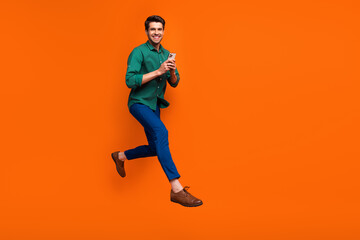 Sticker - Full body cadre of young funky businessman running with smartphone enjoy shopping no commission estore isolated on orange color background