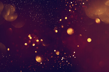 Wall Mural - Golden abstract bokeh on black background. Celebrating Christmas, New Year or other holidays.