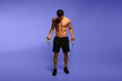 Full length image of a man with an athletic and fit body, posing in the studio with a bare torso, showing six abs pack, isolated on the violet background.