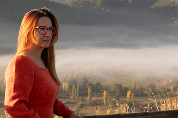 girl in nature with background landscape with fog and green mountains