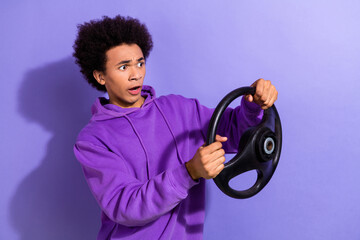 Wall Mural - Portrait of handsome person wear violet hoodie hold steering wheel look at accident empty space isolated on purple color background