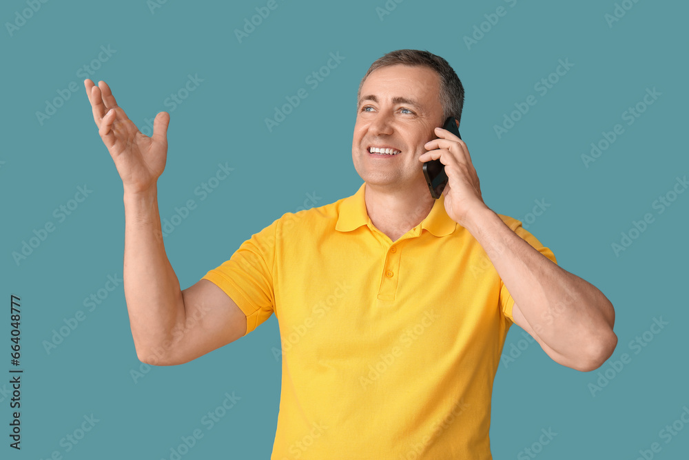 Mature man talking by mobile phone on blue background