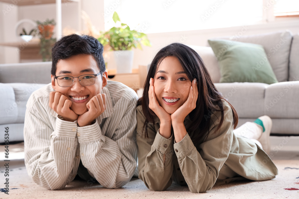 Young Asian friends lying on floor at home