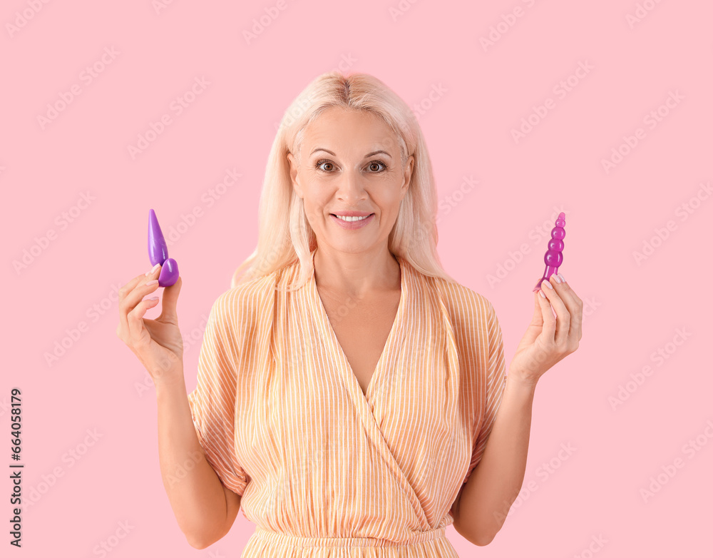 Mature woman with anal plugs on pink background