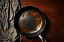 Flat Lay Of Old Vintage Black Cast-iron Frying Pan Isolated On Retro Wooden Background, With Copy Space.