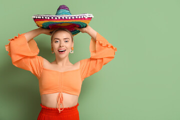 Canvas Print - Pretty young woman with sombrero on green background