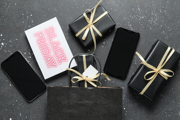 Sticker - Black Friday sale greeting card with mobile phones, gift boxes and shopping bag on dark grunge background