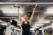 © Dusan Petkovic - Portrait of a happy sportswoman doing pullups in a gym.