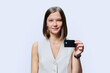 © Valerii Honcharuk - Young woman with bank credit card in hands on white studio background.