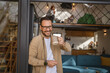 One adult man stand in at door of tiny house happy smile hold cup