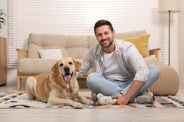 Poster - Man with adorable Labrador Retriever dog at home. Lovely pet