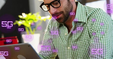 Poster - Animation of multiple 5g texts over smiling caucasian man watching video on digital tablet at cafes