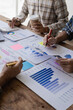 © MrAshi - Analyzing business financial reports on laptop and laptop document graphs during corporate meeting discussion which shows successful teamwork Vertical close-up image