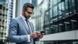 © Marta B - Businessman in a suit reads a message on his phone while walking through the city's business district