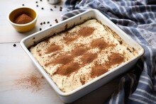 freshly made tiramisu in a square baking dish, ready to be served