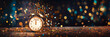 Midnight on New Year eve 2024, alarm clock on panoramic bokeh lights glittering background with copy space