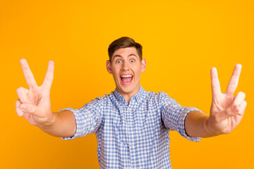 Photo of young satisfied smiling good mood brunet hair guy after barber shop showing v-sign peaceful person isolated on yellow color background