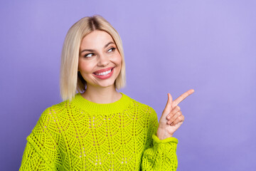 Poster - Photo of cheerful dreamy woman dressed knitted sweater showing finger looking empty space isolated violet color background