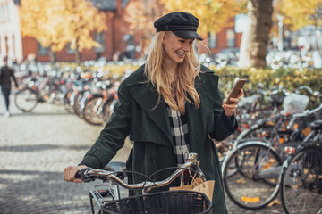 Wall Mural - Attractive young woman using a smartphone in the city