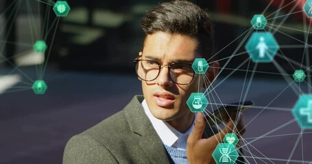 Poster - Animation of connected icons globes over biracial man using voice assistant on smartphone