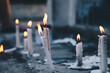 Several lighted candles in front of the tomb during a visit to a dead family member's  grave. Selective focus.
