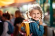 Happy school girl wearing schoolbag in the school.