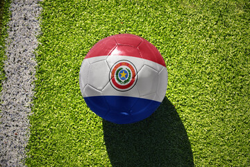 football ball with the flag of paraguay on the green field near the white line