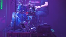 Close-up Of A Drummer Behind A Blue Drum Kit. A Man Rhythmically Playing With His Hands And Feet. Side View. Drummer Playing On Stage