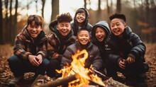 A Group Of Asian Boys. A Rustic Camping Site With A Roaring Bonfire.
