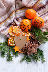 Wall Mural - Christmas holiday background. Knitted sweater, fresh citrus fruits decorated cloves, dry orange slices, fir branches, cones and heart paper card on wooden table. Festive winter season. top view