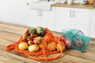 Wall Mural - Eco bags with different ripe vegetables on counter in kitchen, closeup