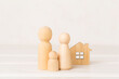 © Liami - Wooden family figures with house on wooden table