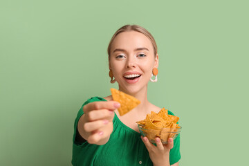 Canvas Print - Pretty young woman with nachos on green background