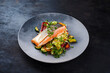 Traditional Mediterranean salmon fish fillet with vegetable cuscus served as close-up on a design bowl with copy space