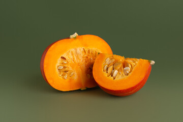 Pumpkin and pumpkin slices on a green background