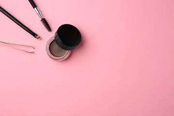 Wall Mural - Eyebrow pomade with henna effect and professional tools on pink background, flat lay. Space for text