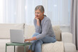 © New Africa - Beautiful senior woman using laptop at home