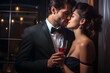 Elegant couple in evening attire, holding champagne, intimately poised for a kiss in a luxurious indoor setting.