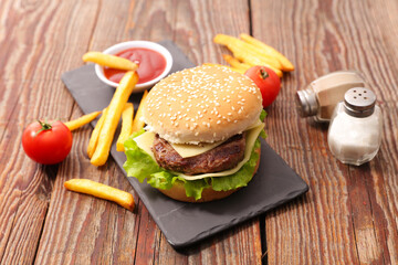 Wall Mural - Tasty burger with beef and cheese, french fries and ketchup