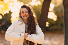 Smiling Young Woman Cold Autumn Portrait In The Forest With The Yellow Leaves At Sunset