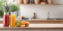 Fruits And Juice On Wooden Tabletop Counter. In Front Of Bright Out Of Focus Kitchen. Copy Space.