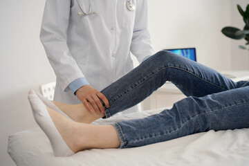 Wall Mural - Doctor and patient are at the usual medical inspection in the clinic. Therapist examines a young woman's knee. Medicine concept