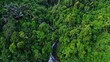 Waterfall flowing at cliff in the middle of tropical forest with aerial shot of drone shot.