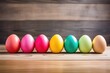 colored easter eggs lined up on a wooden table